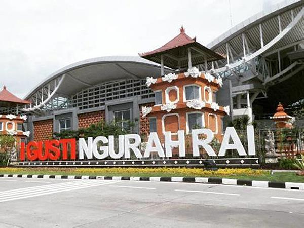 A traveler getting their passport stamped at Ngurah Rai International Airport.